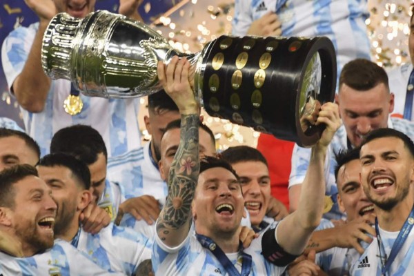 Argentina's Lionel Messi holds the trophy as he celebrates on the podium with teammates after winning the Conmebol 2021 Copa America football tournament final match against Brazil at Maracana Stadium in Rio de Janeiro, Brazil, on July 10, 2021. - Argentina won 1-0. (Photo by NELSON ALMEIDA / AFP)
