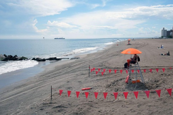 NEW YORK, NEW YORK - JULY 01: Lifeguards keep watch along the beach at Brooklyn's Coney Island on the first day that swimming is allowed at New York City beaches on July 01, 2020 in New York City. Area beaches had been closed to swimming due to concerns of crowding at beaches and the risk of spread of the coronavirus. Spencer Platt/Getty Images/AFP== FOR NEWSPAPERS, INTERNET, TELCOS & TELEVISION USE ONLY ==