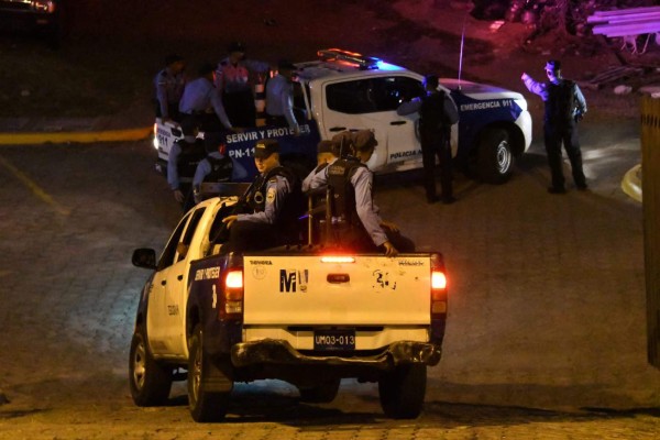 National Police agents escort a convoy transporting Honduran deputies Elvin Ernesto Santos, Rodolfo Irias Navas and Celim Discua Elvir to jail, after a hearing in Tegucigalpa, on July 23, 2018. 37 people, including deputies and public servants, were accused by the Public prosecutor's office and the OAS Mission to Support the Fight against Corruption and Impunity in Honduras, of abuse of authority, fraud, misappropriation of funds, laundering and public document falsification, as part of the 'Pandora' case. / AFP PHOTO / ORLANDO SIERRA