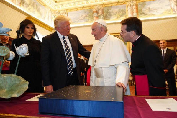 Pope Francis (2ndR) exchanges gifts with US President Donald Trump (2ndL) and US First Lady Melania Trump during a private audience at the Vatican on May 24, 2017. US President Donald Trump met Pope Francis at the Vatican today in a keenly-anticipated first face-to-face encounter between two world leaders who have clashed repeatedly on several issues. / AFP PHOTO / POOL / Evan Vucci