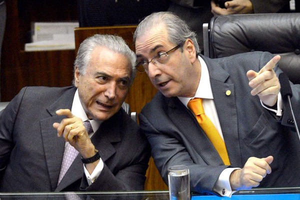 This photo released by Agencia Brasil shows Brazilian President Michel Temer (L) and former president of the Chamber of Deputies, Eduardo Cunha, talking during a ceremony in Congress in Brasilia on November 18, 2015.Temer was secretly taped by one of the owners of J&F Investimentos - the family holding company that controls the JBS meat processing company - giving the green light to a bribery scheme to keep Cunha quiet, the Brazilian newspaper O Globo reported on May 17, 2017. / AFP PHOTO / AGENCIA BRASIL / ANTONIO CRUZ / RESTRICTED TO EDITORIAL USE-MANDATORY CREDIT 'AFP PHOTO/AGENCIA BRASIL/ANTONIO CRUZ' NO MARKETING NO ADVERTISING CAMPAIGNS-DISTRIBUTED AS A SERVICE TO CLIENTS