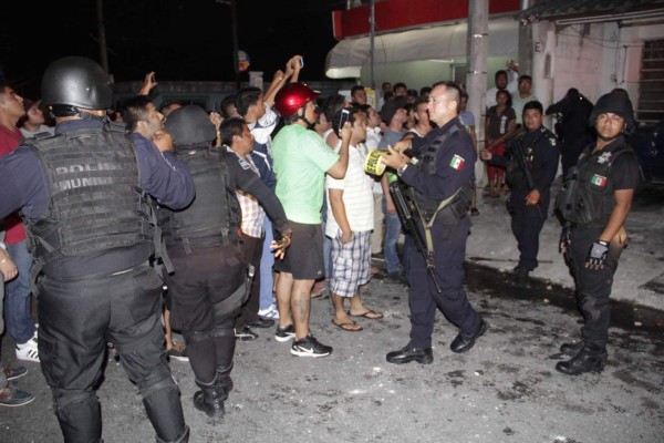 MEX40. CANCÚN (MÉXICO), 19/05/2017.- Policías municipales de Cancún en el estado de Quintana Roo (México), intentan contener a la turba de personas que intentaba linchar a un presunto ciudadano ruso de nombre Aleksey Makeev que se venía dedicando a insultar a los mexicanos mientras los grababa en video para después subirlos a las redes sociales y a Youtube. Después de que se difundiera uno de estos videos en redes sociales y medios de comunicación, decenas de habitantes de este lugar sitiaron al extranjero en su vivienda, lanzaron piedras y dejaron al hombre en grave estado de salud. EFE/Alonso Cupul