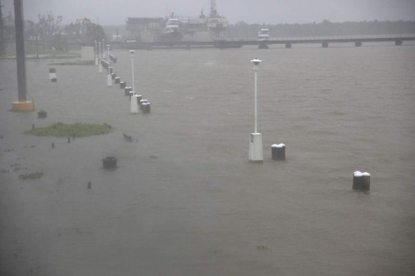 Benches and walkways are flooded by water along the Berwick River in Morgan City, Louisiana ahead of Tropical Storm Barry Saturday, July 13,2019. - Tropical Storm Barry is the first tropical storm system of 2019 to make landfall in the United States the storm is around 10 miles offshore from Louisiana. Barry will dump up to two feet of rain along with strong winds and storm-surge flooding according to weather reports. (Photo by Seth HERALD / AFP)