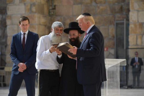 US President Donald Trump listens to Rabbi Shmuel Rabinovitch (C) during a visit to the Western Wall, the holiest site where Jews can pray, in Jerusalems Old City on May 22, 2017. On the left, Trump's son-in-law and senior advisor Jared Kushner. / AFP PHOTO / MANDEL NGAN