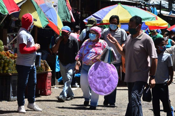 People wear facemasks at a market in Tegucigalpa on June 19, 2020 during the COVID-19 coronavirus pandemic. - The Honduran National System of Risk Management (SINAGER) announced the temporary closure of at least six popular markets as of this Friday to 'readjust' biosecurity measures to prevent further contagion. Honduras has recorded 343 deaths and 10,739 confirmed cases of the new coronavirus. (Photo by ORLANDO SIERRA / AFP)