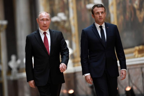 French President Emmanuel Macron (R) and Russian President Vladimir Putin (L) walk in the Galerie des Batailles (Gallery of Battles) as they arrive for a joint press conference following their meeting at the Versailles Palace, near Paris, on May 29, 2017.French President Emmanuel Macron hosts Russian counterpart Vladimir Putin in their first meeting since he came to office with differences on Ukraine and Syria clearly visible. / AFP PHOTO / POOL AND AFP PHOTO / STEPHANE DE SAKUTIN