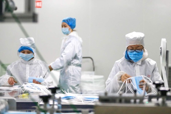 Workers produce protective face masks at a factory in Qingdao in China's eastern Shandong province, on February 6, 2020, to support the supply of medical materials during a virus outbreak that originated from Hubei's provincial capital city of Wuhan. - The number of confirmed infections in China's coronavirus outbreak has reached 28,018 nationwide with 3,694 new cases reported, the National Health Commission said on February 6. (Photo by STR / AFP) / China OUT
