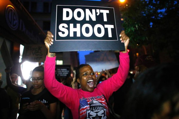 A woman holds a banner during a protest in support of the Black lives matter movement in New York on July 09, 2016. The gunman behind a sniper-style attack in Dallas was an Army veteran and loner driven to exact revenge on white officers after the recent deaths of two black men at the hands of police, authorities have said. Micah Johnson, 25, had no criminal history, Dallas police said in a statement. / AFP PHOTO / KENA BETANCUR