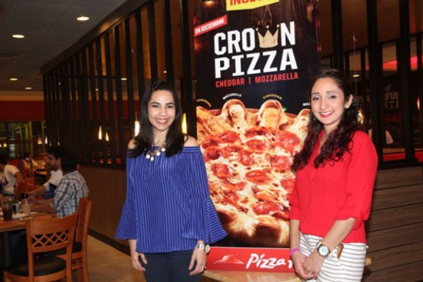 Erika Hernández y Giselle García en el lanzamiento de la pizza del mes llamada la Crown Pizza.