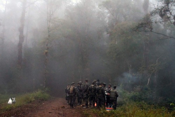 Honduran soldiers walk in the mountains of Yerba Buena, Rincon de Dolores, in the municipality of Lepaterique, at the spot where Hilda Hernandez, the sister of Honduran President Juan Orlando Hernandez, died in a helicopter crash, 60 km northwest of Tegucigalpa, on December 17, 2017. Hernandez, an engineer and former communications and press minister in her brother's government, died in a helicopter crash along with the pilot, copilot and three other people. / AFP PHOTO / ORLANDO SIERRA