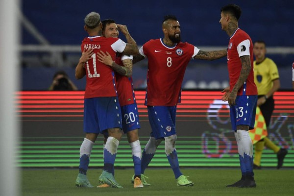 Chile's Eduardo Vargas (L) celebrates after scoring a goal against Argentina after teammate Arturo Vidal (2-R) missed a penalty during their Conmebol Copa America 2021 football tournament group phase match at the Nilton Santos Stadium in Rio de Janeiro, Brazil, on June 14, 2021. (Photo by MAURO PIMENTEL / AFP)