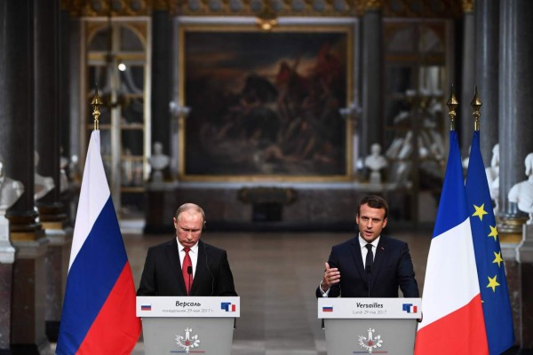 French President Emmanuel Macron (R) gestures as he delivers a speech during a joint press conference with Russian President Vladimir Putin (L) following their meeting at the Versailles Palace, near Paris, on May 29, 2017.French President Emmanuel Macron hosts Russian counterpart Vladimir Putin in their first meeting since he came to office with differences on Ukraine and Syria clearly visible. / AFP PHOTO / CHRISTOPHE ARCHAMBAULT