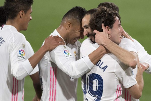 Real Madrid's Spanish defender Alvaro Odriozola (R) celebrates with teammates after scoring a goal during the Spanish League football match between Cadiz and Real Madrid at the Ramon de Carranza stadium in Cadiz on April 21, 2021. (Photo by JORGE GUERRERO / AFP)
