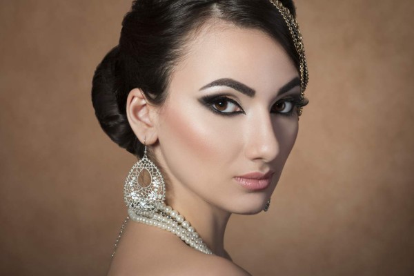 Portrait of young beautiful asian woman with evening make-up over beige background