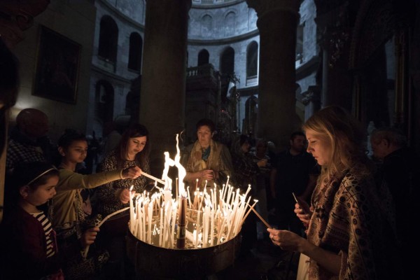 Jerusalem (Israel), 14/04/2019.- Visitors light candles near the tomb of Jesus Christ in the Church of the Holy Sepulchre in Jerusalem's Old City, 14 April 2019.Christian pilgrim mark the Palm Sunday as many Christian churches symbolically marks the biblical account of the entry of Jesus Christ into Jerusalem, signaling the start of the Holy Week before Easter. (Estados Unidos, Jerusalén) EFE/EPA/ABIR SULTAN
