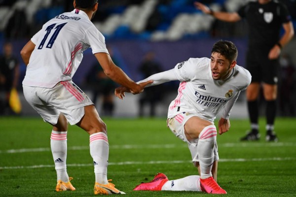 Real Madrid's Uruguayan midfielder Federico Valverde (R) celebrates with Spain's forward Marco Asensio after scoring a goal that was first cleared by the VAR then ruled offside during the UEFA Champions League group B football match between Real Madrid and Shakhtar Donetsk at the Alfredo di Stefano stadium in Valdebebas on the outskirts of Madrid on October 21, 2020. (Photo by GABRIEL BOUYS / AFP)