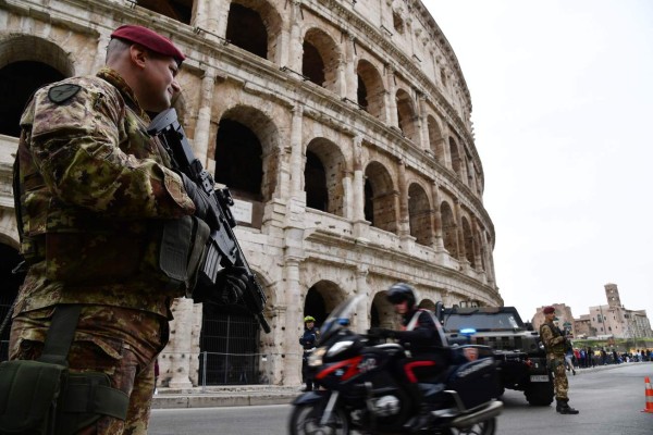 Italian soldiers stand at a 'check-point' near the ancient Colosseum on March 24, 2017 in Rome. EU leaders will meet Pope Francis today in Vatican on the eve of the celebrations marking the 60th anniversary of the bloc's founding Treaty of Rome. / AFP PHOTO / Vincenzo PINTO