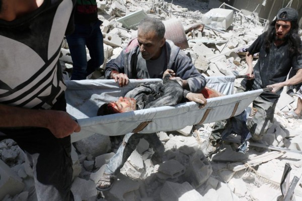 Voluntarios sacan de entre los escombros de un edificio bombardeado a un bebé en al-Kalasa en el norte de Alepo. Fotos: AFP