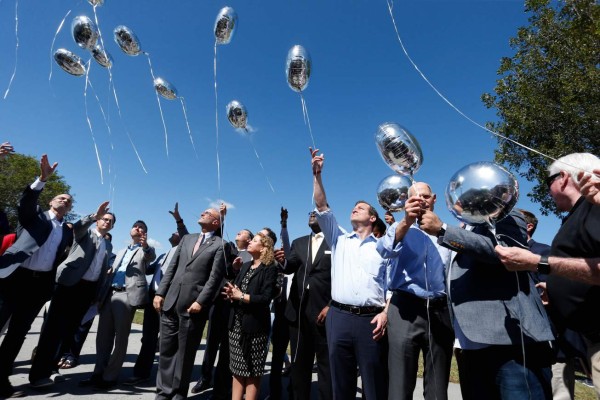 City, county and state officials release balloons in honor of the victims during a prayer vigil for the Marjory Stoneman Douglas High School shooting at Parkridge Church in Coral Springs, Florida on February 15, 2018. The heavily armed teenager who gunned down students and adults at a Florida high school was charged Thursday with 17 counts of premeditated murder, court documents showed.Nikolas Cruz, 19, killed fifteen people in a hail of gunfire at Marjory Stoneman Douglas High School in Parkland, Florida. Two others died of their wounds later in hospital, the sheriff's office said. / AFP PHOTO / RHONA WISE