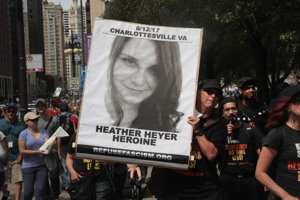 CHICAGO, IL - AUGUST 13: A demonstrator carries a sign remembering Heather Heyer during a protest on August 13, 2017 in Chicago, Illinois. Heyer was killed and 19 others were injured yesterday in Charlottesville, Virginia when a car plowed into a group of activists who were preparing to march in opposition to a nearby white nationalist rally. Two police officers were also killed when a helicopter they were using to monitor the rally crashed. Scott Olson/Getty Images/AFP