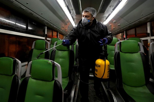 A Tehran Municipality worker cleans a bus to avoid the spread of the COVID-19 illness on February 26, 2020. - Iran said Tuesday its coronavirus outbreak, the deadliest outside China, had claimed 15 lives and infected nearly 100 others -- including the country's deputy health minister. The Islamic republic's neighbours have imposed travel restrictions and strict quarantine measures after reporting their first cases in recent days, mostly in people with links to Iran. (Photo by ATTA KENARE / AFP)