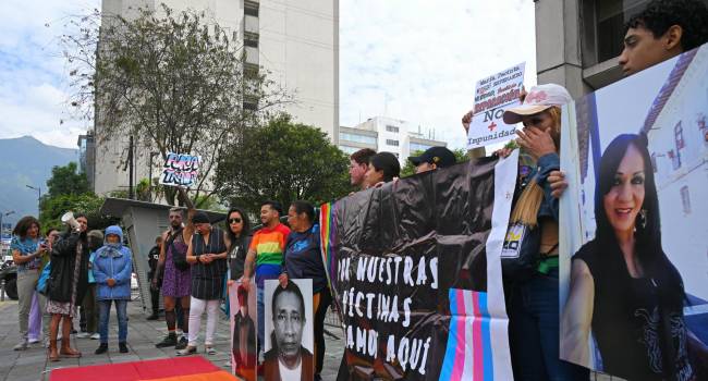 Personas sostienen carteles y fotografías de víctimas de violencia homofóbica frente al edificio de la Fiscalía del Estado para conmemorar el Día Internacional contra la Homofobia en Estados Unidos.