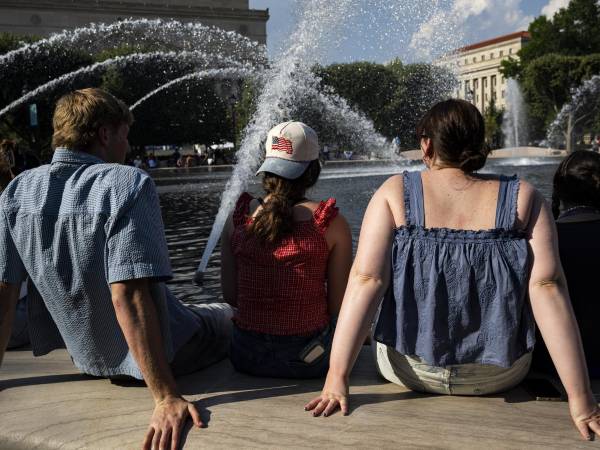 Personas se refrescan en la fuente del Jardín de Esculturas de la Galería Nacional de Arte, en el National Mall de Washington, DC (EE.UU.), durante temperaturas de calor extremo. EFE/GRAEME SLOAN