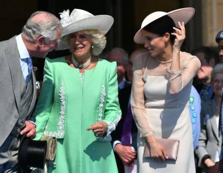 Britain's Prince Charles, Prince of Wales (L) and his wife Britain's Camilla, Duchess of Cornwall (C), talk with Britain's Meghan, Duchess of Sussex, as her husband Britain's Prince Harry, Duke of Sussex (unseen), speaks during the Prince of Wales's 70th Birthday Garden Party at Buckingham Palace in London on May 22, 2018.<br/>The Prince of Wales and The Duchess of Cornwall hosted a Garden Party to celebrate the work of The Prince's Charities in the year of Prince Charles's 70th Birthday. / AFP PHOTO / POOL / Dominic Lipinski