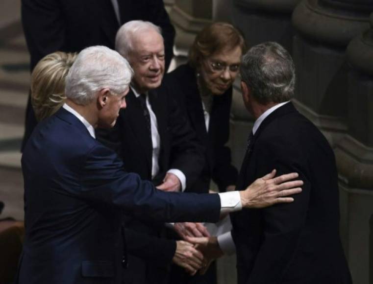 El expresidente Bush hijo saluda a sus pares, Bill Clinton y Jimmy Carter a su llegada a la Catedral Nacional para el funeral de su padre.