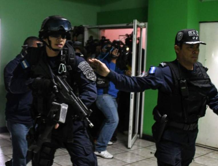 Miembros de la unidad de policía de élite hondureña Tigres llegan a las instalaciones de Radio Globo para arrestar al periodista hondureño David Romero. AFP