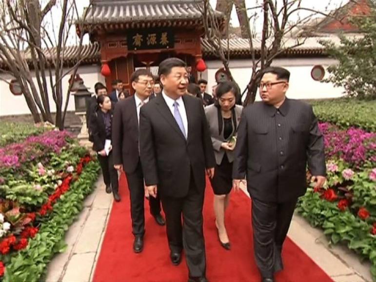 Bajo las enormes lámparas del Palacio del pueblo, Kim Jong Un, en traje Mao gris oscuro, pasó revista a tropas chinas junto al presidente Xi -como es costumbre para todos los dirigentes extranjeros de visita en China.