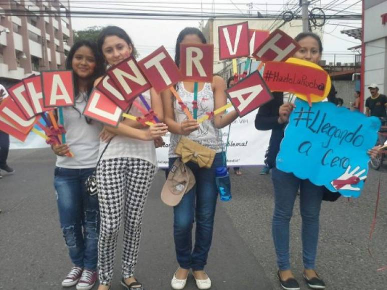 Jóvenes sampedranas participan en la marcha que conmemora el Día Mundial de la Lucha contra el Sida.