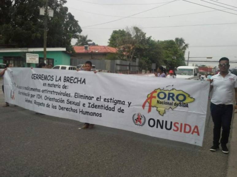 Activistas marchan por la tercera avenida de San Pedro Sula en conmemoración del Día Mundial de la Lucha contra el Sida.