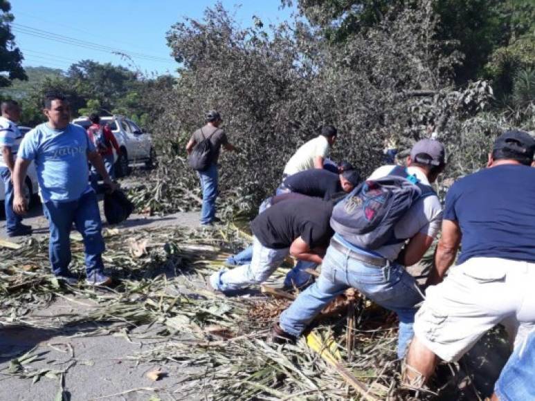 Ciudadanos en Cofradía, Cortés, liberando algunas vías que estaban con escombros después de un paro nacional en la zona norte, mediante toma de carreteras, que fue desbaratado hoy por las fuerzas armadas.