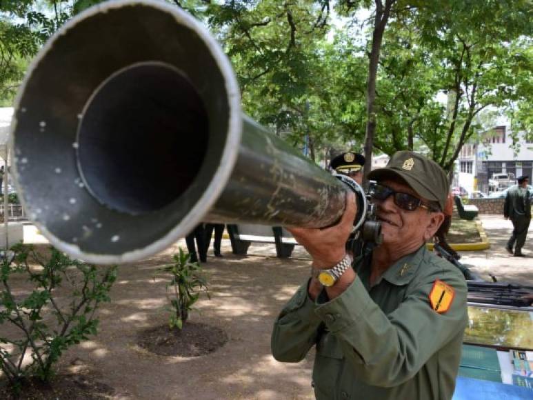 Un veterano de guerra posa con un lanzador de cohetes antitanque portátil durante una ceremonia por el 47 aniversario de la guerra entre Honduras y El Salvador. AFP