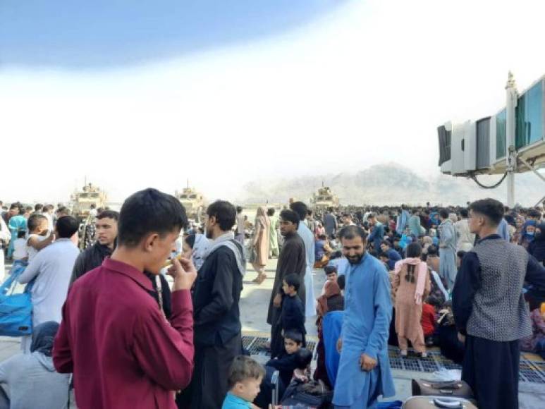 Afghans crowd at the tarmac of the Kabul airport on August 16, 2021, to flee the country as the Taliban were in control of Afghanistan after President Ashraf Ghani fled the country and conceded the insurgents had won the 20-year war. (Photo by - / AFP)