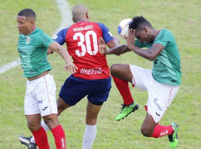 Eddie Hernández salte entre Luis Garrido y Bryan Johnson disputando el balón.