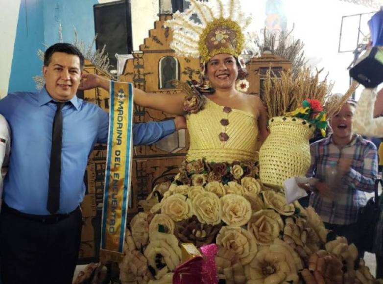 El traje estaba decorado con flores de tusa. En la foto, la maestra recibiendo la banda como la ganadora.