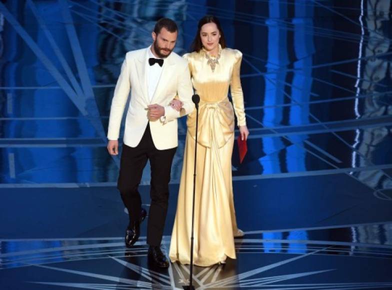 Jamie Dornan y Dakota Johnson, una de las parejas más esperadas en los premios Óscar. Sin embargo, la joven actriz apareció con un vestido dorado de manga larga y con cuello alto que fue muy criticado.