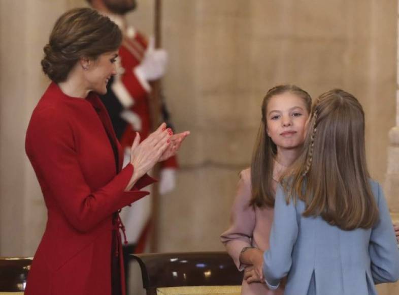 La reina Letizia observa a sus hijas saludarse tras la imposición de la condecoración.