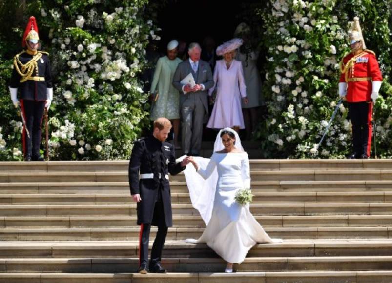 TOPSHOT - Britain's Prince Harry, Duke of Sussex and his wife Meghan, Duchess of Sussex emerge from the West Door of St George's Chapel, Windsor Castle, in Windsor, on May 19, 2018 after their wedding ceremony. / AFP PHOTO / POOL / Ben STANSALL