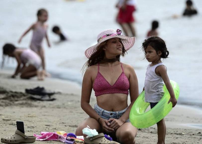 Una guapa mujer y su pequeña hija disfrutaron del sol y la playa en Puerto Cortés. (AFP)