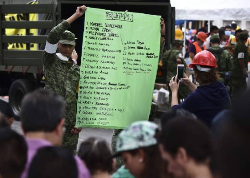 Los soldados de la Marina mexicana han sido desplegados para ayudar en las tareas de rescate. En la imagen, un militar muestra un cartel con el nombre de varias personas rescatadas de los escombros de un edificio en la Ciudad de México.