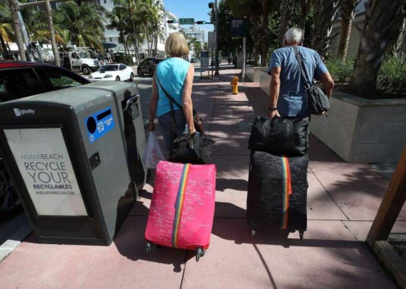 MIAMI BEACH, FL - SEPTEMBER 07: Tourist Bjorg Aasen and Arne Forsmo walk to catch a shuttle to a shelter as the city announced a mandatory evacuation ahead of the approaching Hurricane Irma on September 7, 2017 in Miami Beach, Florida. Current tracks for Hurricane Irma shows that it could hit south Florida this weekend. Mark Wilson/Getty Images/AFP<br/><br/>== FOR NEWSPAPERS, INTERNET, TELCOS & TELEVISION USE ONLY ==<br/><br/>