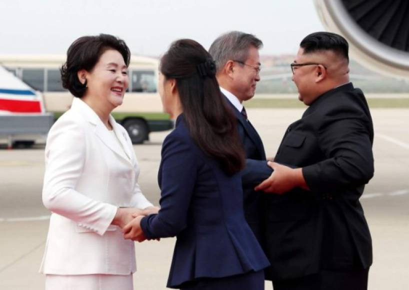 Acompañados por sus esposas, bromearon durante unos minutos, mientras cientos de personas agitaban banderas norcoreanas y emblemas de la unificación.