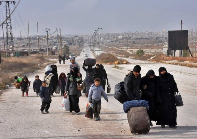 Familias sirias huyen de Aleppo cargando unas pocas pertenencias ante el asedio de las fuerzas pro regimen.