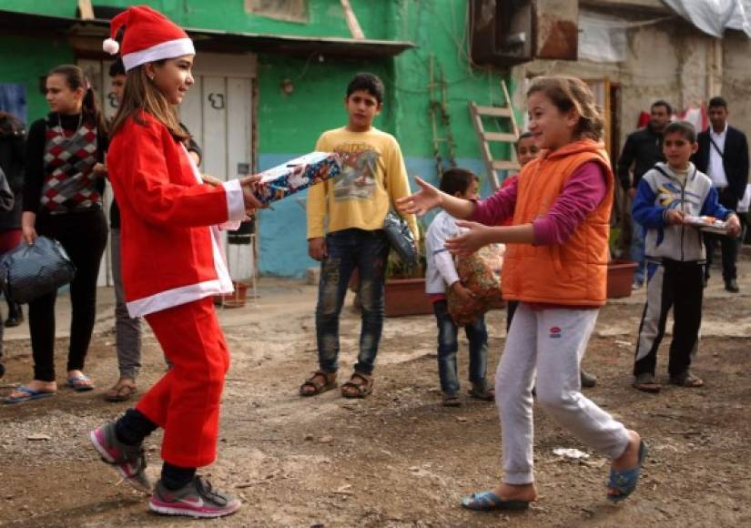LÍBANO. La felicidad de recibir un regalo. Chloe, una adolescente cristiana libanesa entrega un regalo a una refugiada siria; actividad organizada por la congregación maronita “Mission de Vie”. Foto: AFP
