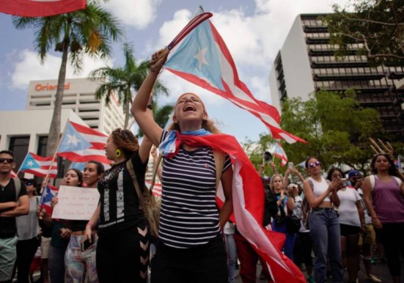Arropados con banderas de Puerto Rico, los manifestantes gritaban 'lo logramos, Ricky, te botamos'.