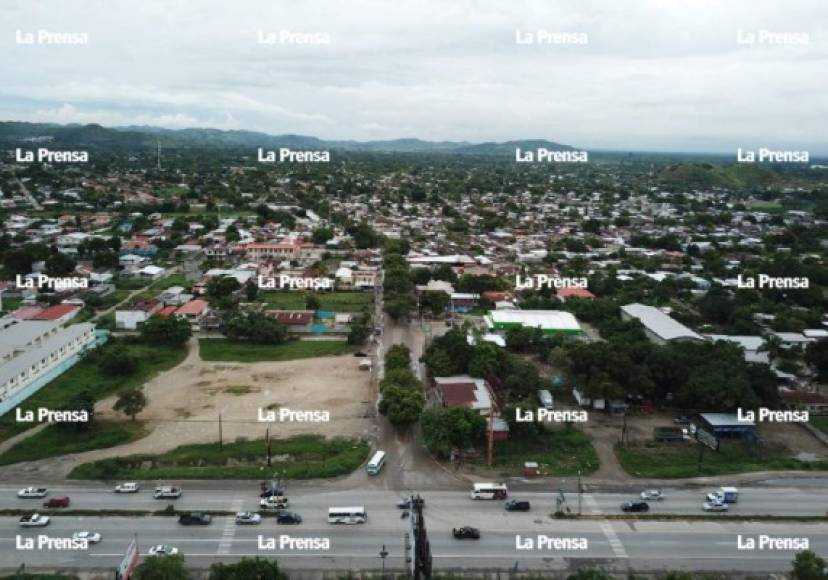 Entrada a la colonia La Planeta durante. La carretera hacia La Lima y el bulevar de la entrada a La Planeta estuvieron anegados varios días con las aguas del Mitch. Después. Las vías públicas permanecen igual que hace 20 años.