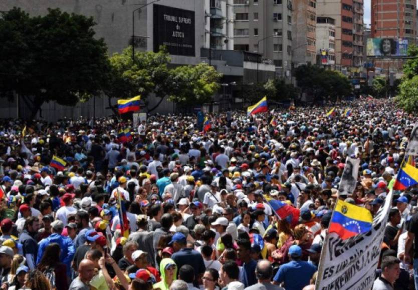 Ondeando banderas venezolanas, vestidos de blanco, multitudes de opositores se concentraban en distintos puntos de Caracas y otras zonas del país para asistir a la inesperada juramentación del jefe del Parlamento, Juan Guaidó como presidente interino de Venezuela.